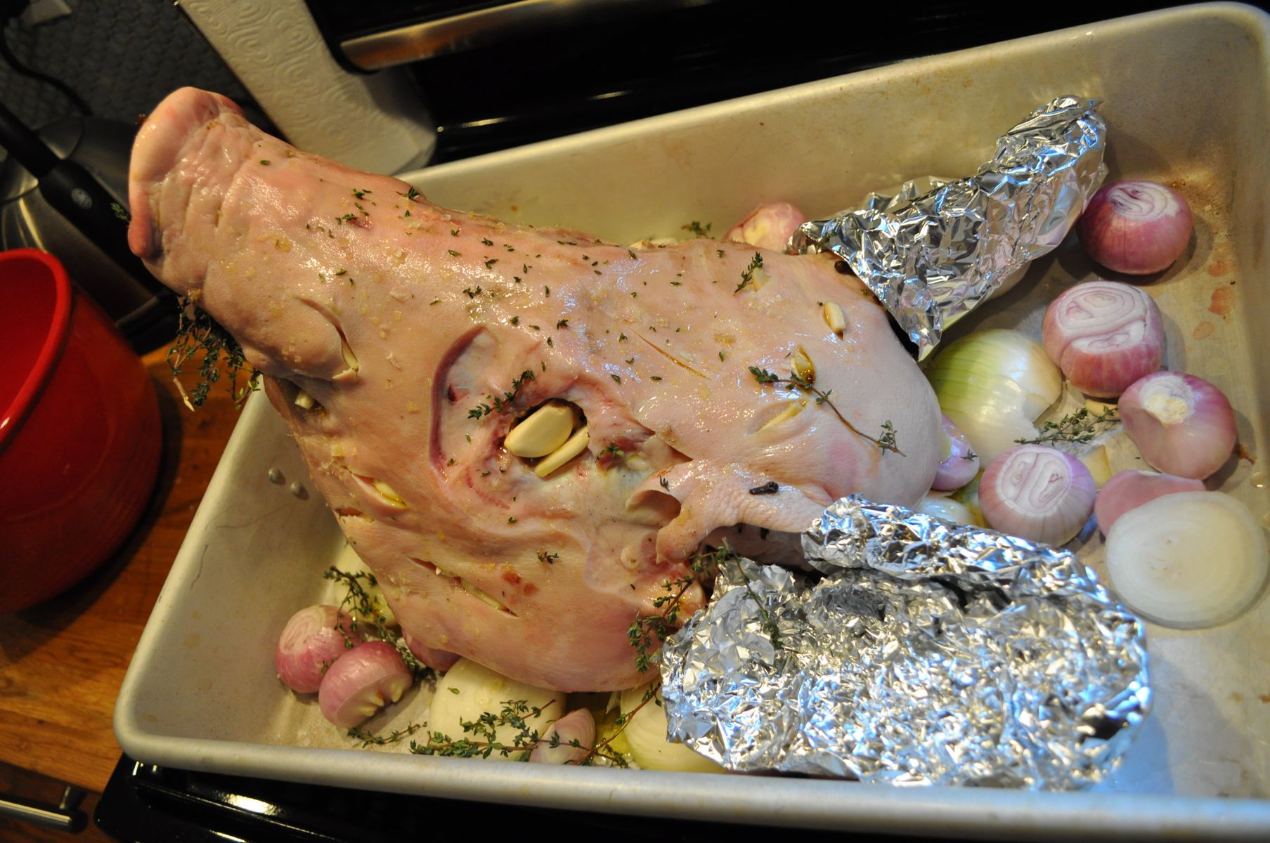 Then we covered her ears in tin foil to stop them from burning in the oven, and put garlic and cloves into the slits made in her skin so the brine cou